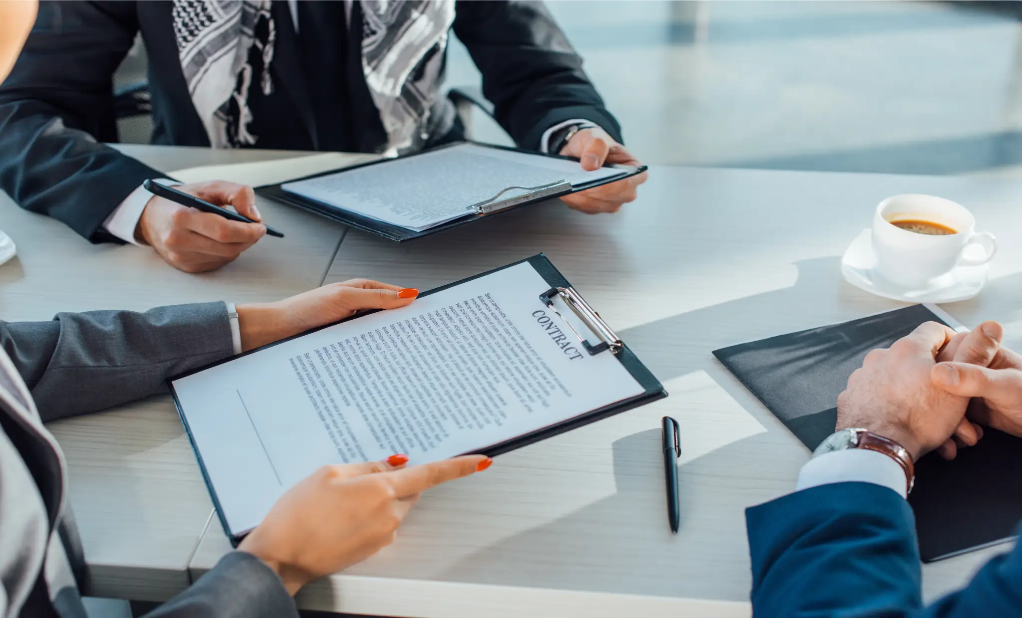 cropped view of business partners holding contract on meeting in office
